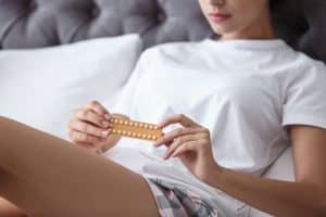 A woman holds birth control pills